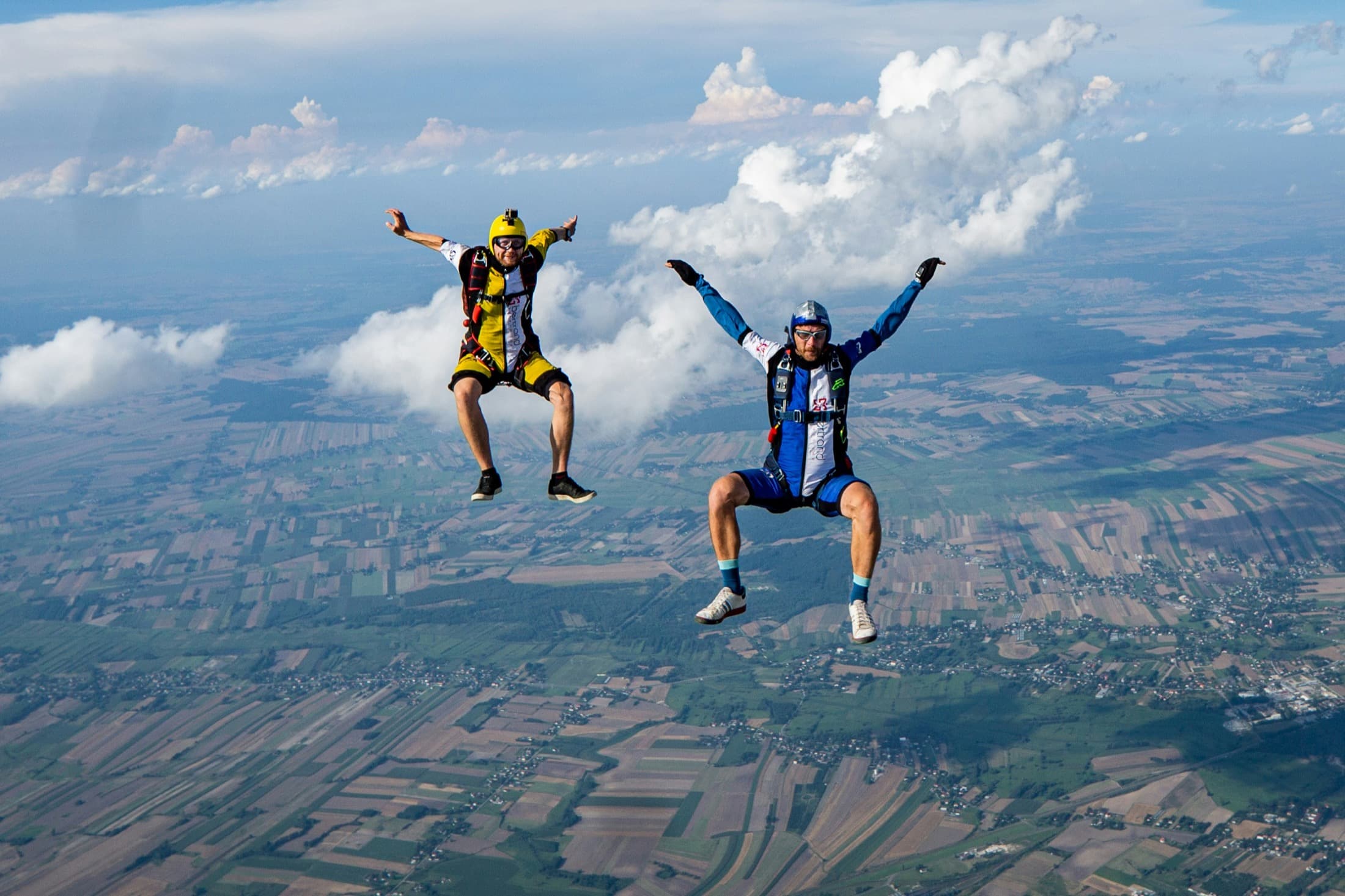 Two flyers in belly formation over the countryside